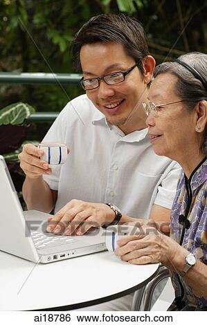 Man and senior woman, looking at laptop View Large Photo Image Stock Photograph - Man and senior woman, looking at laptop. Fotosearch