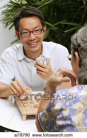 Man and senior woman playing a game of chess View Large Photo Image Stock Image - Man and senior woman playing a game of chess. Fotosearch