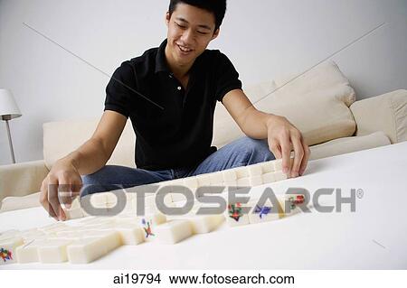 Man arranging mahjong tiles on the table View Large Photo Image Picture - Man arranging mahjong tiles on the table. Fotosearch