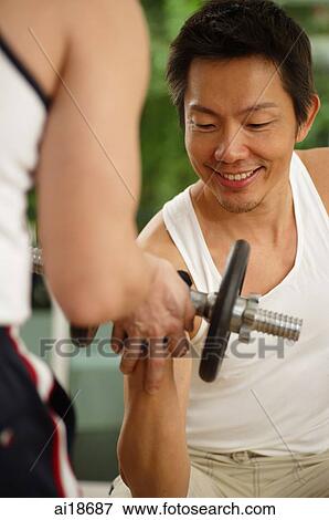 Man carrying barbell, another man assisting him View Large Photo Image Stock Photo - Man carrying barbell, another man assisting him. Fotosearch