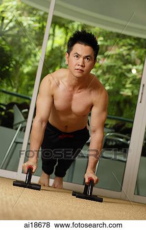 Stock Photo - Man doing push ups in gym. Fotosearch