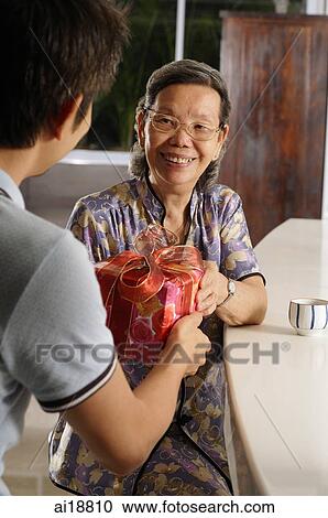 Man giving gift to senior woman View Large Photo Image Stock Image - Man giving gift to senior woman. Fotosearch