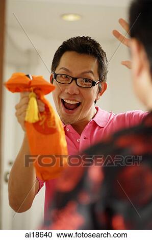 Man greeting visitor at door, holding wine bottle View Large Photo Image Stock Image - Man greeting visitor at door, holding wine bottle. Fotosearch