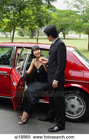 Stock Photography - Man helping woman out of car. Fotosearch