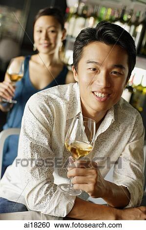 Man holding a drink, leaning on counter, woman in the background View Large Photo Image Stock Image - Man holding a drink, leaning on counter, woman in the background. Fotosearch