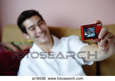 Man holding camera, taking photograph of himself View Large Photo Image Stock Photo - Man holding camera, taking photograph of himself. Fotosearch