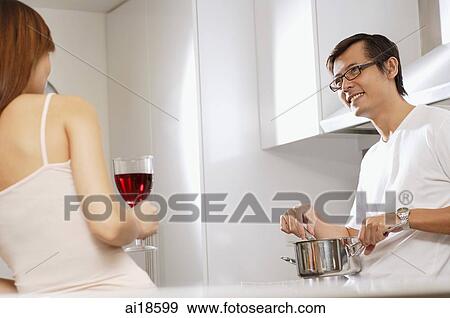 Man holding cooking pot, facing woman with wine glass View Large Photo Image Stock Photo - Man holding cooking pot, facing woman with wine glass. Fotosearch