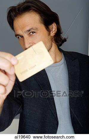 Stock Image - Man holding credit card. Fotosearch