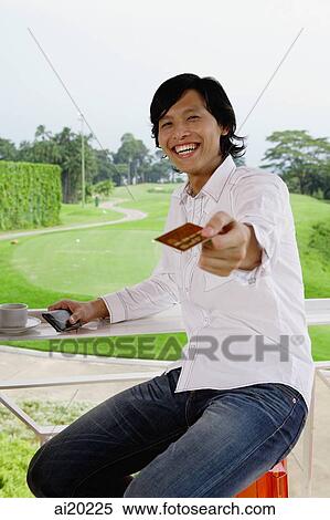 Man holding credit card, towards camera, golf course behind him View Large Photo Image Stock Photography - Man holding credit card, towards camera, golf course behind him. Fotosearch