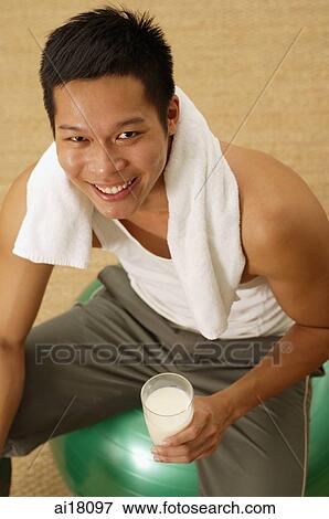 Man holding glass of milk, smiling at camera View Large Photo Image Stock Photo - Man holding glass of milk, smiling at camera. Fotosearch