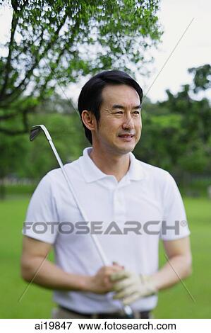 Man holding golf club, looking away, portrait View Large Photo Image Stock Photo - Man holding golf club, looking away, portrait. Fotosearch