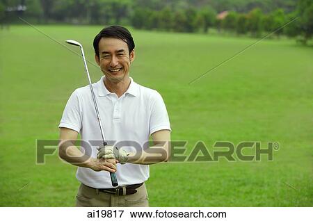 Man holding golf club, smiling at camera View Large Photo Image Stock Photo - Man holding golf club, smiling at camera. Fotosearch