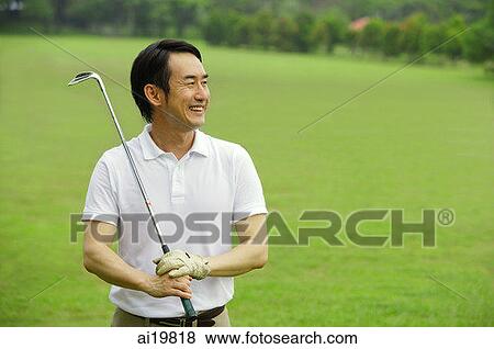 Man holding golf club, smiling, looking away View Large Photo Image Stock Photo - Man holding golf club, smiling, looking away. Fotosearch