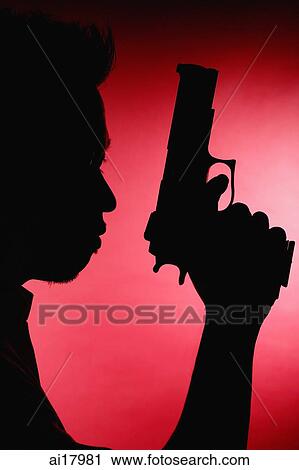 Man holding gun, silhouette shot View Large Photo Image Stock Image - Man holding gun, silhouette shot. Fotosearch