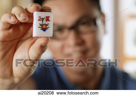 Man holding mahjong tile with the Chinese script for Summer View Large Photo Image Stock Photo - Man holding mahjong tile with the Chinese script for Summer. Fotosearch