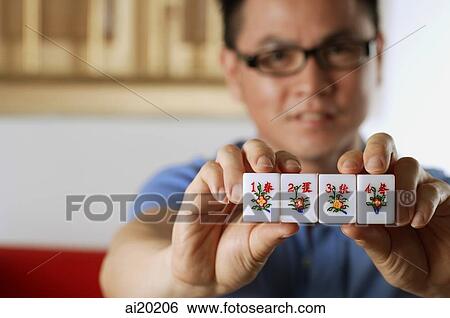 Man holding mahjong tiles with Chinese characters for Spring, Summer, Autumn and Winter View Large Photo Image Stock Photograph - Man holding mahjong tiles with Chinese characters for Spring, Summer, Autumn and Winter. Fotosearch