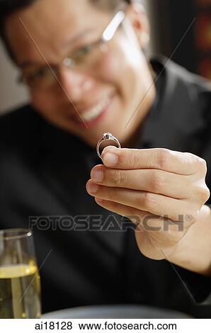 Stock Photo - Man holding ring towards camera. Fotosearch