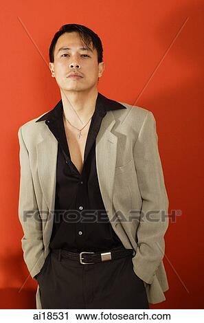 Man in black shirt and beige jacket, hands in pockets, looking at camera View Large Photo Image Stock Image - Man in black shirt and beige jacket, hands in pockets, looking at camera. Fotosearch