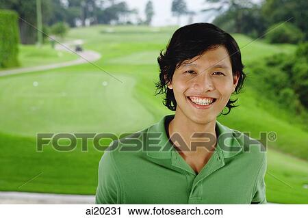 Man in green polo shirt, smiling at camera, golf course behind him View Large Photo Image Stock Image - Man in green polo shirt, smiling at camera, golf course behind him. Fotosearch