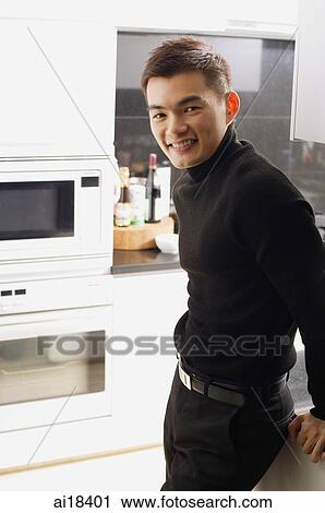 Man in kitchen, looking at camera View Large Photo Image Stock Image - Man in kitchen, looking at camera. Fotosearch
