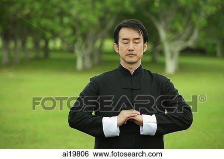 Stock Photograph - Man in park, meditating, eyes closed. Fotosearch