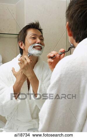 Picture - Man in robe, shaving face. Fotosearch