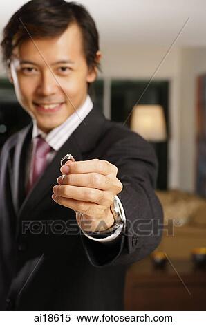 Man in suit smiling at camera, holding a ring View Large Photo Image Stock Photography - Man in suit smiling at camera, holding a ring. Fotosearch