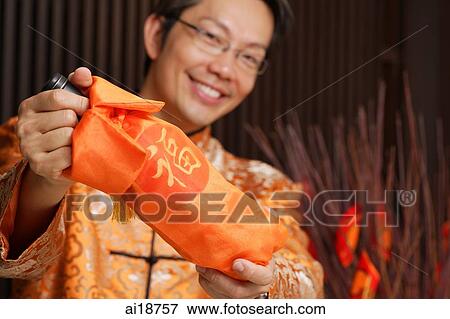 Man in traditional Chinese clothing holding wine bottle out to camera View Large Photo Image Stock Photo - Man in traditional Chinese clothing holding wine bottle out to camera. Fotosearch