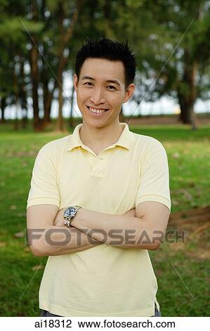 Man in yellow polo shirt, smiling at camera, arms crossed View Large Photo Image Stock Image - Man in yellow polo shirt, smiling at camera, arms crossed. Fotosearch