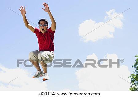 Man jumping in mid air, arms outstretched, mouth open View Large Photo Image Picture - Man jumping in mid air, arms outstretched, mouth open. Fotosearch