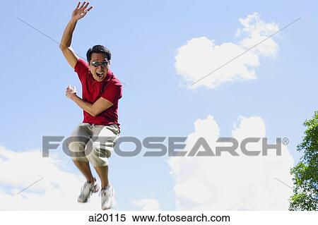 Stock Photography - Man jumping in mid air, hand raised, mouth open. Fotosearch