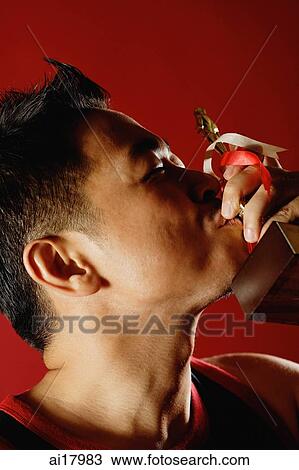 Stock Image - Man kissing trophy. Fotosearch