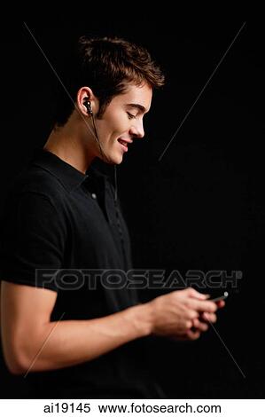Man listening to MP3 player, side view View Large Photo Image Stock Photography - Man listening to MP3 player, side view. Fotosearch