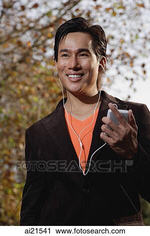 Stock Image - Man listening to MP3 player. Fotosearch