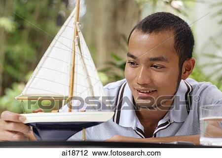Man looking a wooden model of boat View Large Photo Image Stock Image - Man looking a wooden model of boat. Fotosearch