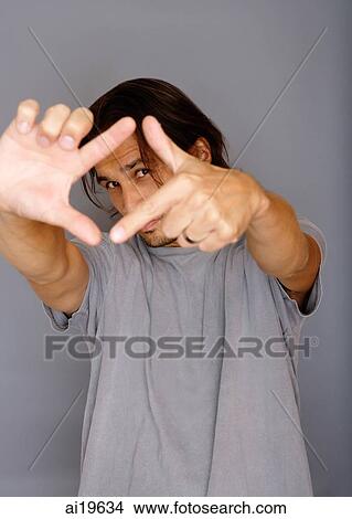 Man making finger frame, looking at camera View Large Photo Image Picture - Man making finger frame, looking at camera. Fotosearch