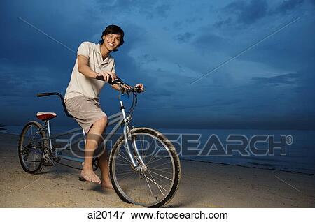 Man on beach, sitting on tandem bicycle View Large Photo Image Stock Photo - Man on beach, sitting on tandem bicycle. Fotosearch