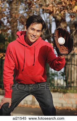 Stock Photography - Man outdoors wearing baseball gloves. Fotosearch