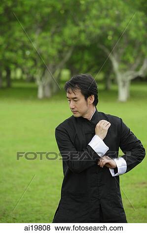 Stock Photo - Man practicing tai chi in park. Fotosearch