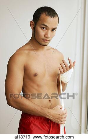 Man rolling bandage around his hand, looking at camera View Large Photo Image Stock Photo - Man rolling bandage around his hand, looking at camera. Fotosearch
