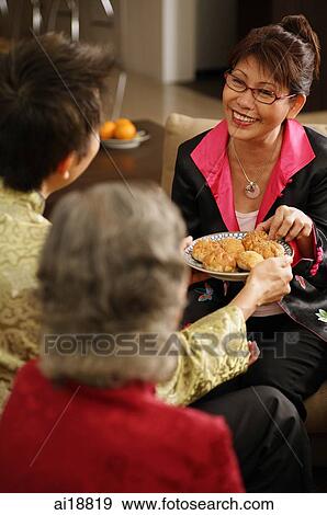 Man serving woman with plate of traditional Chinese cakes View Large Photo Image Stock Photo - Man serving woman with plate of traditional Chinese cakes. Fotosearch