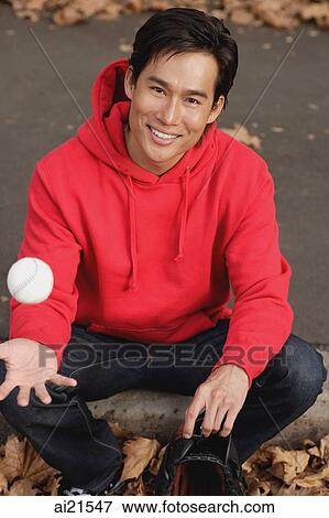 Man sitting on ground, tossing baseball View Large Photo Image Stock Photo - Man sitting on ground, tossing baseball. Fotosearch