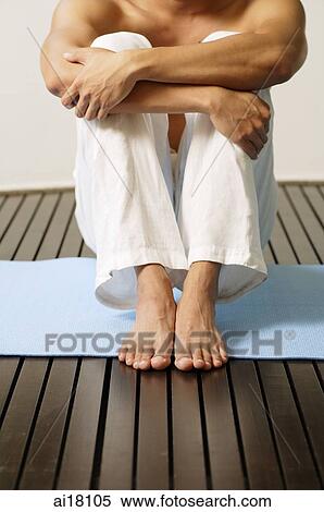 Man sitting on mat, hugging knees, arms crossed, cropped image View Large Photo Image Stock Photography - Man sitting on mat, hugging knees, arms crossed, cropped image. Fotosearch