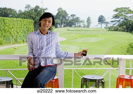 Man sitting on stool, leaning on railing, gold course behind him View Large Photo Image Stock Image - Man sitting on stool, leaning on railing, gold course behind him. Fotosearch