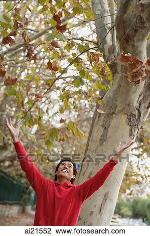 Man standing beneath a tree, arms outstretched View Large Photo Image Stock Image - Man standing beneath a tree, arms outstretched. Fotosearch