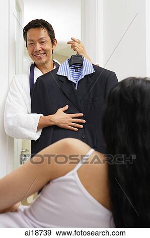 Man standing in front of woman, holding shirt and jacket on a hanger View Large Photo Image Stock Photo - Man standing in front of woman, holding shirt and jacket on a hanger. Fotosearch