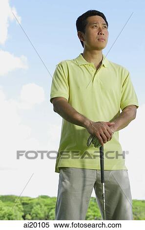 Man standing, leaning on golf club, looking away View Large Photo Image Stock Photography - Man standing, leaning on golf club, looking away. Fotosearch