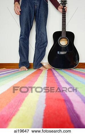 Man standing next to guitar, low section View Large Photo Image Stock Photo - Man standing next to guitar, low section. Fotosearch