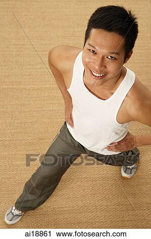 Man standing with legs apart, hands on hip, looking at camera View Large Photo Image Stock Image - Man standing with legs apart, hands on hip, looking at camera. Fotosearch