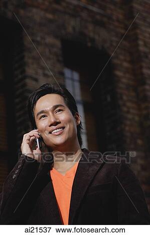 Man using mobile phone, smiling, looking away View Large Photo Image Stock Photo - Man using mobile phone, smiling, looking away. Fotosearch